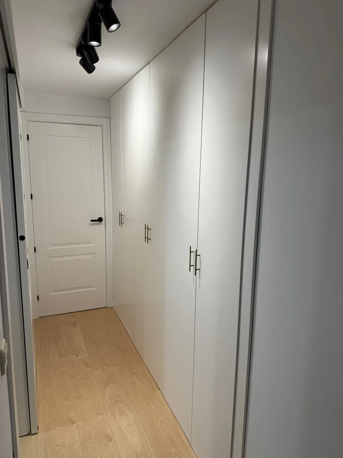 Pasillo con puerta lacada de plafones y armario lacado en blanco